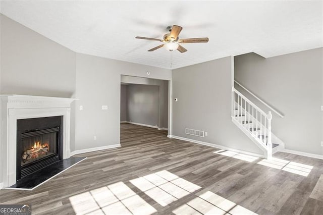 5667 Cascade, Atlanta, GA 30336 - unfurnished living room featuring wood finished floors, a lit fireplace, ceiling fan, and stairway