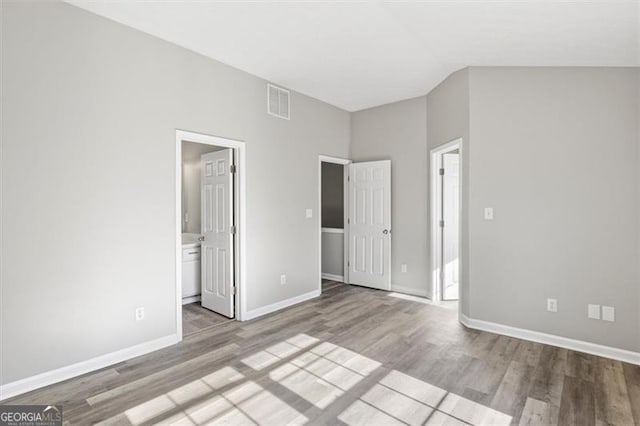 5667 Cascade, Atlanta, GA 30336 - unfurnished bedroom featuring wood finished floors, lofted ceiling, and ensuite bath