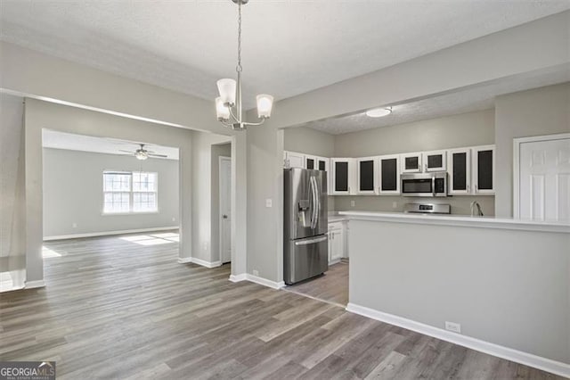 5667 Cascade, Atlanta, GA 30336 - kitchen featuring appliances with stainless steel finishes, white cabinets, glass insert cabinets, light countertops, and a chandelier