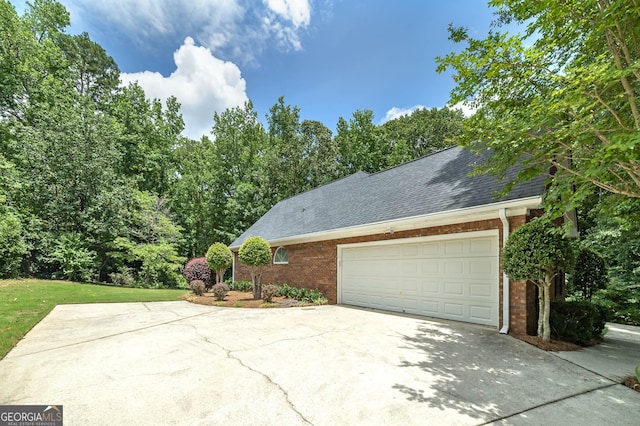 110 Chardonnay Oaks Dr, Mcdonough, GA 30252 - view of home's exterior with brick siding, a shingled roof, driveway, and a garage