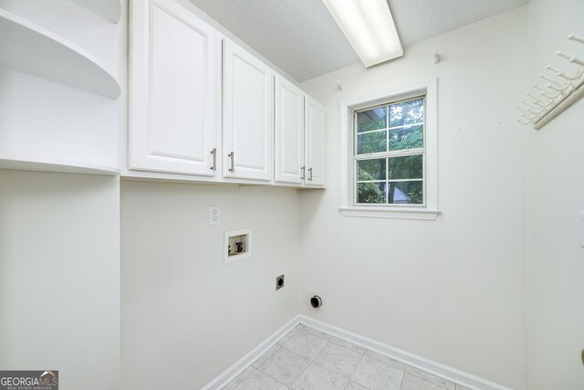 110 Chardonnay Oaks Dr, Mcdonough, GA 30252 - laundry area featuring cabinet space, electric dryer hookup, washer hookup, a textured ceiling, and light tile patterned flooring