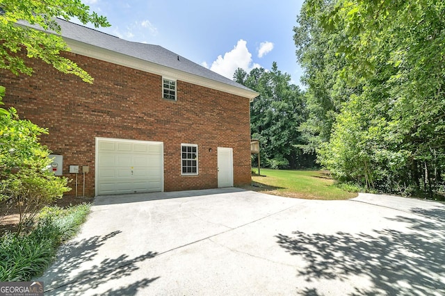 110 Chardonnay Oaks Dr, Mcdonough, GA 30252 - view of side of property with driveway, an attached garage, brick siding, and a lawn