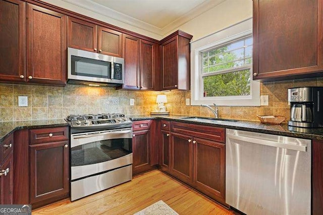 3202 Saute Way, Avondale Estates, GA 30002 - kitchen with stainless steel appliances, ornamental molding, light wood-style floors, dark stone counters, and tasteful backsplash