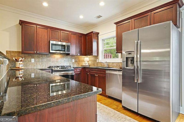 3202 Saute Way, Avondale Estates, GA 30002 - kitchen featuring stainless steel appliances, ornamental molding, dark stone countertops, light wood-type flooring, and backsplash