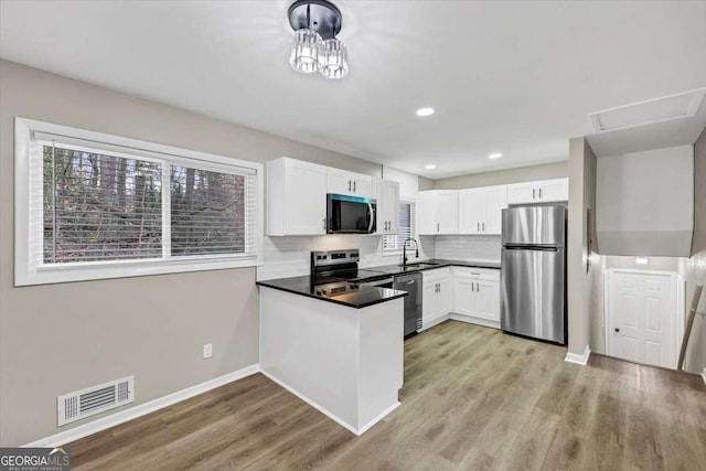 847 Magna Carta Dr NW, Atlanta, GA 30318 - kitchen with appliances with stainless steel finishes, healthy amount of natural light, white cabinets, a peninsula, and recessed lighting