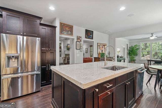 452 Rockford Pass, Marietta, GA 30064 - kitchen with appliances with stainless steel finishes, an island with sink, light stone countertops, a ceiling fan, and dark brown cabinets