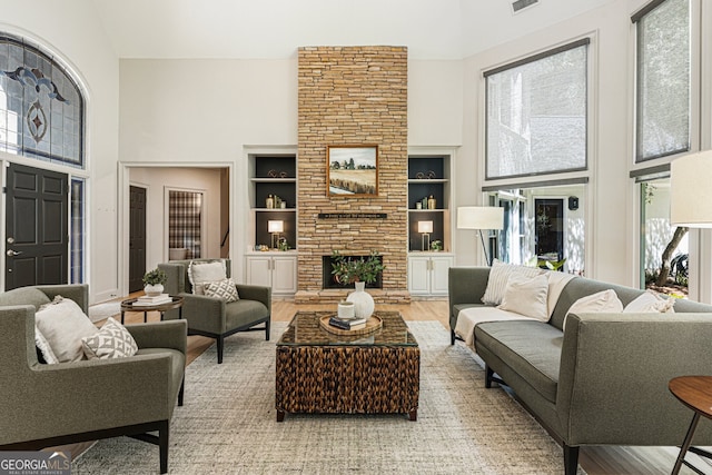 625 Wynfield Ct, Roswell, GA 30076 - living room with a high ceiling, wood finished floors, built in shelves, and a stone fireplace