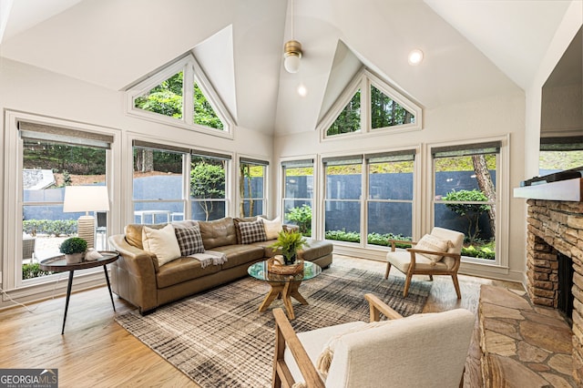 625 Wynfield Ct, Roswell, GA 30076 - living room featuring high vaulted ceiling, a stone fireplace, light wood-style flooring, and a ceiling fan