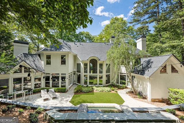 625 Wynfield Ct, Roswell, GA 30076 - rear view of property featuring a chimney, a patio area, a sunroom, a shingled roof, and an in-ground hot tub