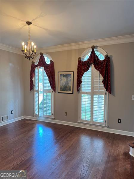 1464 Chatsworth Trce, Lawrenceville, GA 30044 - spare room featuring wood finished floors, ornamental molding, and a chandelier