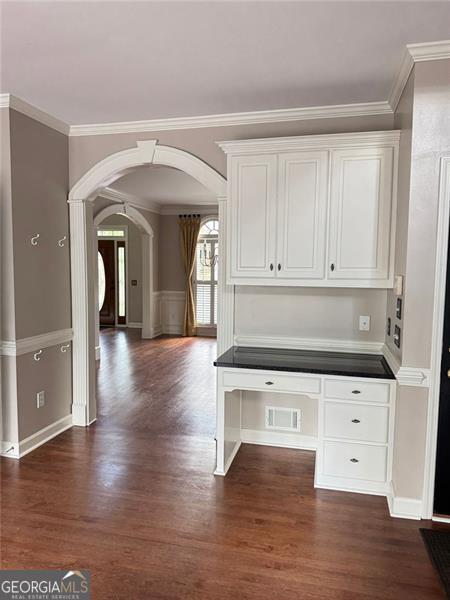 1464 Chatsworth Trce, Lawrenceville, GA 30044 - unfurnished office with arched walkways, dark wood-style floors, and crown molding