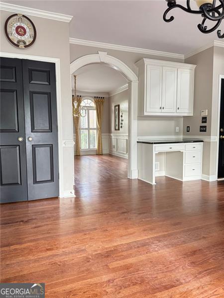 1464 Chatsworth Trce, Lawrenceville, GA 30044 - entryway with crown molding, arched walkways, light wood-style floors, a chandelier, and a decorative wall
