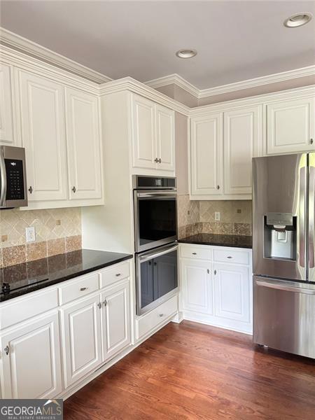 1464 Chatsworth Trce, Lawrenceville, GA 30044 - kitchen with stainless steel appliances, white cabinets, tasteful backsplash, ornamental molding, and recessed lighting