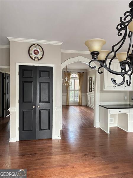 1464 Chatsworth Trce, Lawrenceville, GA 30044 - entryway with crown molding, wood finished floors, arched walkways, a chandelier, and a decorative wall