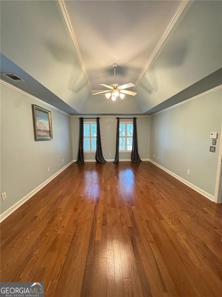 1464 Chatsworth Trce, Lawrenceville, GA 30044 - empty room featuring a ceiling fan, lofted ceiling, dark wood finished floors, and crown molding
