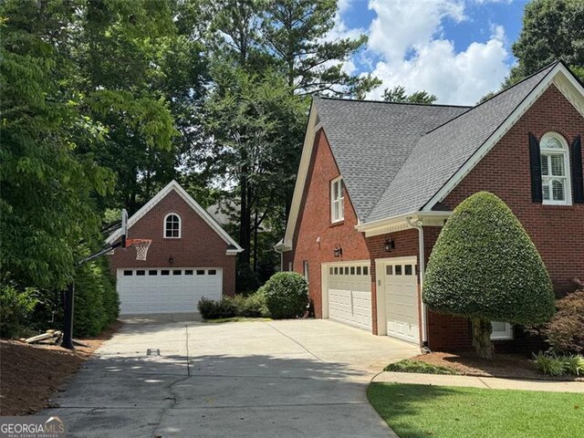 1464 Chatsworth Trce, Lawrenceville, GA 30044 - view of home's exterior featuring concrete driveway, brick siding, and a shingled roof