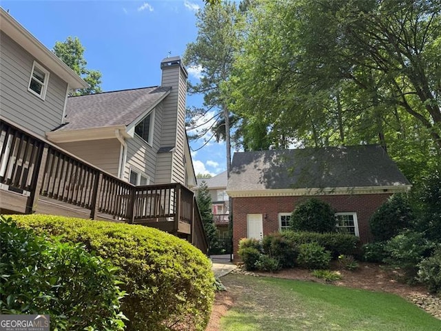 1464 Chatsworth Trce, Lawrenceville, GA 30044 - view of side of home featuring a wooden deck, a chimney, brick siding, and a shingled roof