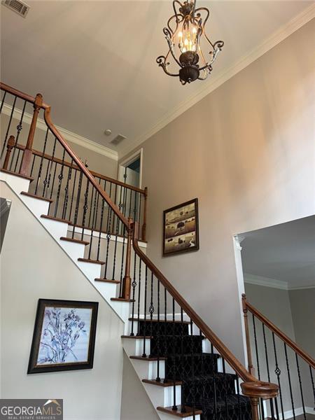 1464 Chatsworth Trce, Lawrenceville, GA 30044 - stairs with a towering ceiling, ornamental molding, and a chandelier