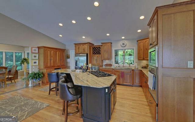 212 Windjammer Dr, Hiawassee, GA 30546 - kitchen with appliances with stainless steel finishes, light stone countertops, a kitchen bar, recessed lighting, and a kitchen island with sink