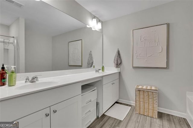 1969 Lanier Harbor Pt, Buford, GA 30518 - bathroom with double vanity, wood finished floors, and a bath