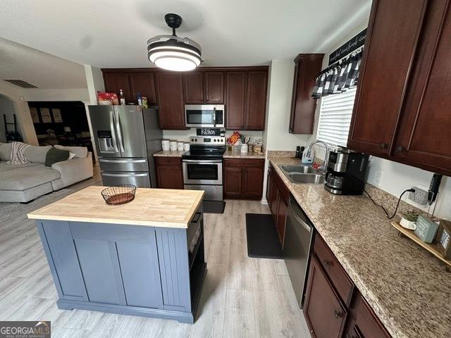 298 Timberwind Dr, Byron, GA 31008 - kitchen with stainless steel appliances, light wood-style flooring, open floor plan, and wood counters
