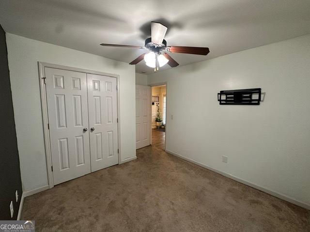298 Timberwind Dr, Byron, GA 31008 - unfurnished bedroom with carpet, a closet, and ceiling fan