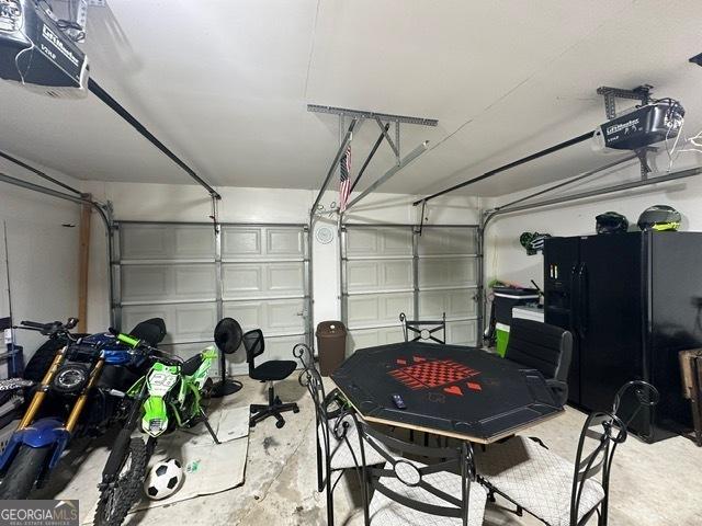 298 Timberwind Dr, Byron, GA 31008 - garage with a garage door opener and freestanding refrigerator