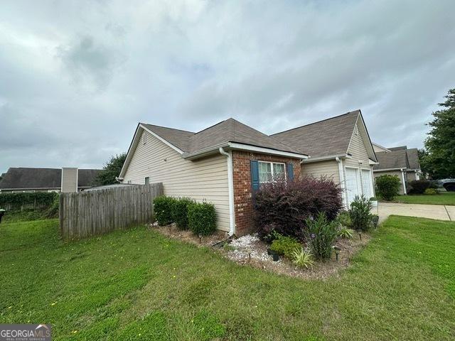 298 Timberwind Dr, Byron, GA 31008 - view of side of property featuring brick siding, driveway, and an attached garage
