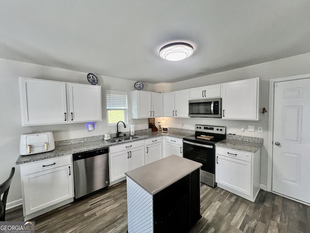 312 Indian River Dr, Jefferson, GA 30549 - kitchen with appliances with stainless steel finishes, dark wood-style floors, white cabinetry, and a center island