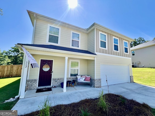 312 Indian River Dr, Jefferson, GA 30549 - view of front of home featuring covered porch, an attached garage, concrete driveway, stone siding, and board and batten siding
