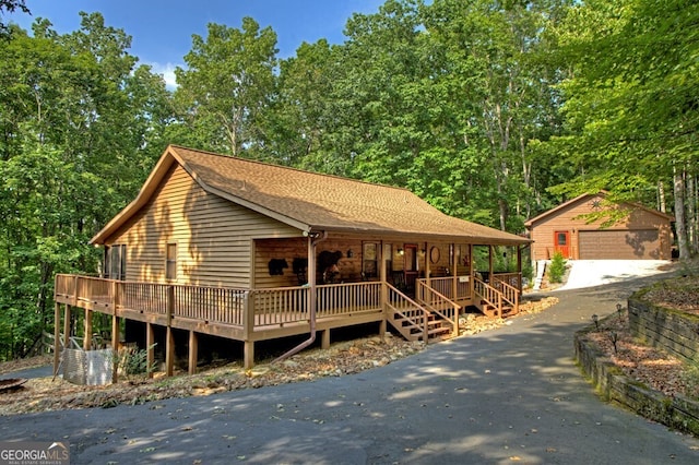 191 Deer Run Rd, Blairsville, GA 30512 - view of front of house with an outdoor structure, a detached garage, covered porch, roof with shingles, and asphalt driveway