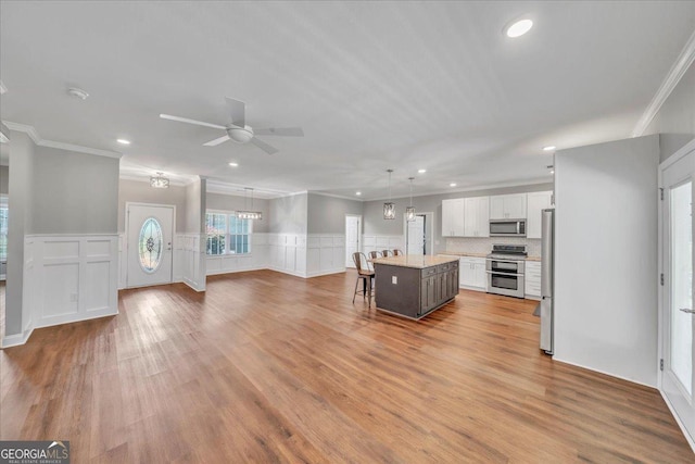 605 Live Oak Way, Dublin, GA 31021 - kitchen with stainless steel appliances, crown molding, recessed lighting, ceiling fan, and a breakfast bar