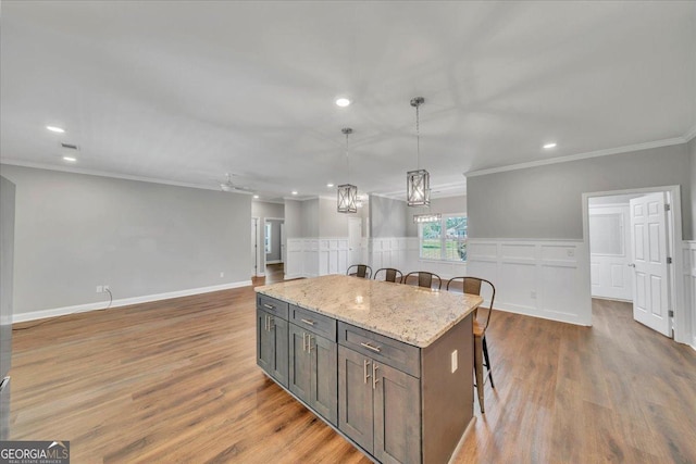 605 Live Oak Way, Dublin, GA 31021 - kitchen featuring a kitchen bar, ornamental molding, a center island, pendant lighting, and wood finished floors