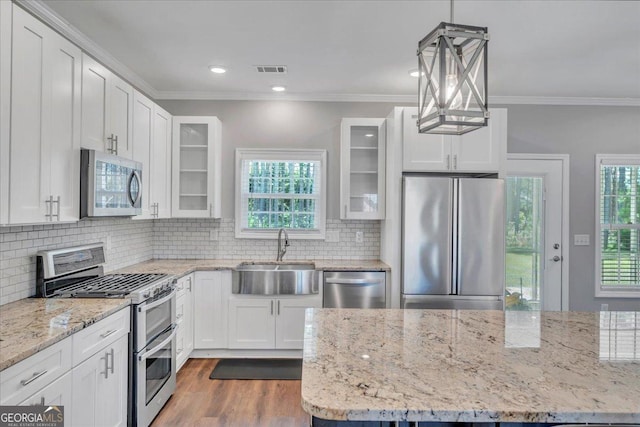 605 Live Oak Way, Dublin, GA 31021 - kitchen featuring appliances with stainless steel finishes, white cabinetry, glass insert cabinets, crown molding, and backsplash