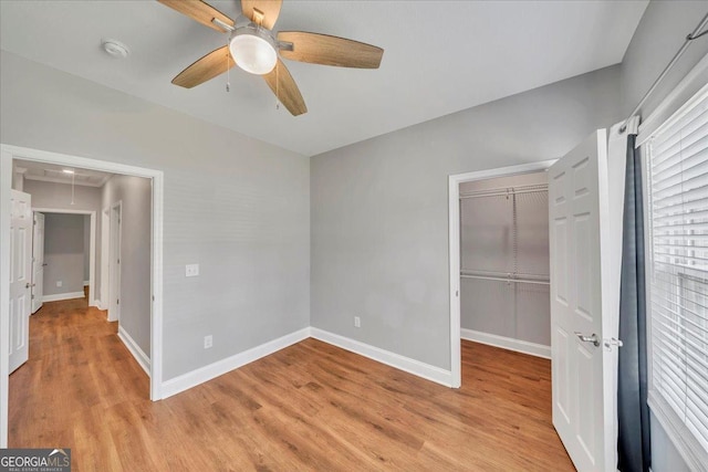605 Live Oak Way, Dublin, GA 31021 - unfurnished bedroom featuring light wood-style flooring, a closet, attic access, a ceiling fan, and a spacious closet