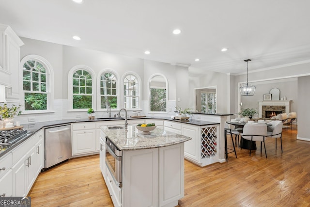 665 Greenview Ter, Milton, GA 30004 - kitchen featuring stainless steel appliances, a kitchen island with sink, recessed lighting, plenty of natural light, and a fireplace