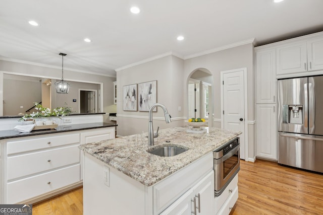 665 Greenview Ter, Milton, GA 30004 - kitchen featuring stainless steel refrigerator with ice dispenser, crown molding, arched walkways, an island with sink, and white cabinetry