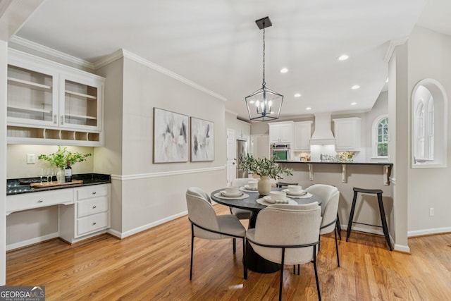 665 Greenview Ter, Milton, GA 30004 - dining space featuring light wood finished floors, a chandelier, built in study area, recessed lighting, and crown molding