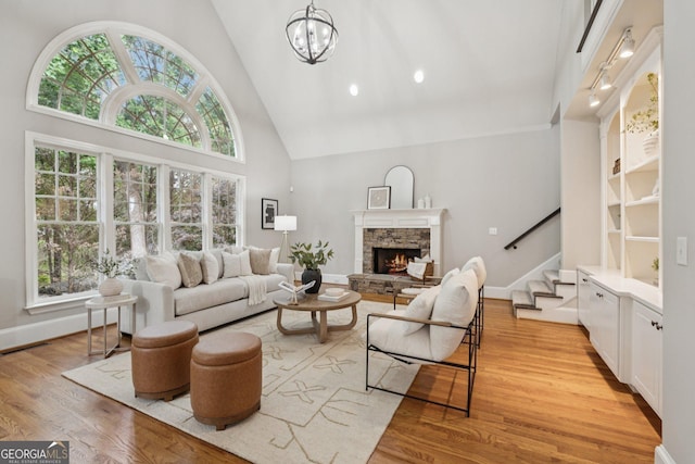 665 Greenview Ter, Milton, GA 30004 - living area featuring high vaulted ceiling, light wood-type flooring, stairs, a fireplace, and a chandelier