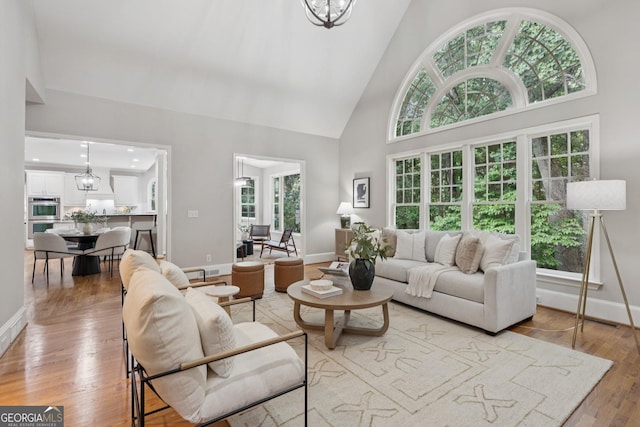 665 Greenview Ter, Milton, GA 30004 - living room with high vaulted ceiling, light wood-style flooring, and a chandelier