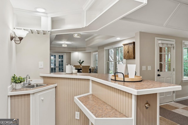 665 Greenview Ter, Milton, GA 30004 - kitchen with light countertops, ornamental molding, a raised ceiling, and a peninsula