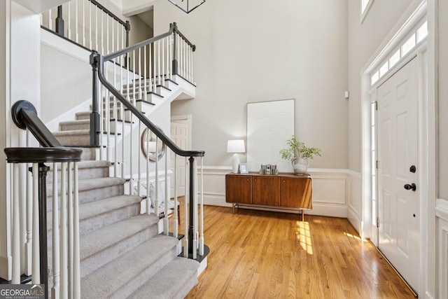 665 Greenview Ter, Milton, GA 30004 - entryway featuring wood finished floors, a towering ceiling, stairs, wainscoting, and a decorative wall