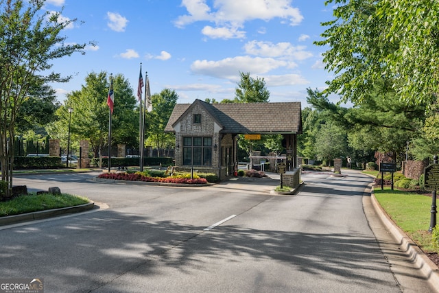 665 Greenview Ter, Milton, GA 30004 - view of asphalt road with curbs, street lighting, and a gated entry