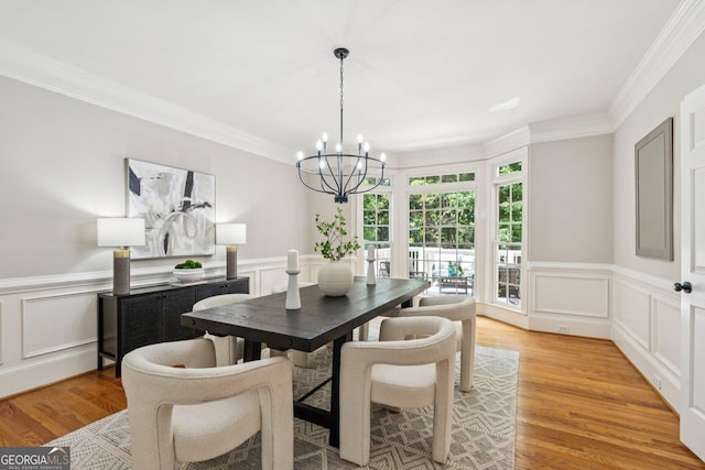 665 Greenview Ter, Milton, GA 30004 - dining space featuring a chandelier, ornamental molding, a decorative wall, light wood finished floors, and wainscoting