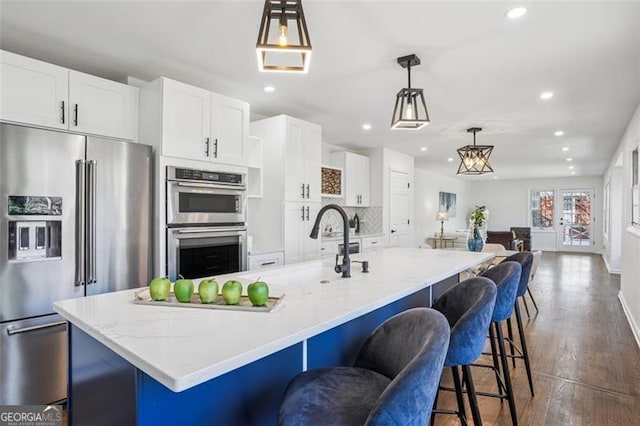 335 Amberidge, Atlanta, GA 30328 - kitchen featuring appliances with stainless steel finishes, recessed lighting, white cabinetry, dark wood-style floors, and a large island