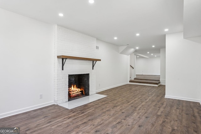 335 Amberidge, Atlanta, GA 30328 - unfurnished living room with a brick fireplace, wood finished floors, recessed lighting, and stairway