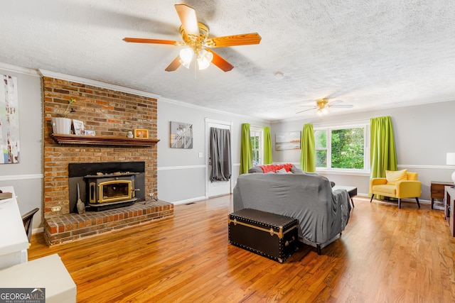 412 Perry Rd, Armuchee, GA 30105 - living room featuring a ceiling fan, light wood-style flooring, a wood stove, a textured ceiling, and crown molding