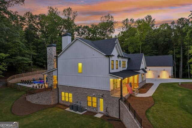 6326 Point Twenty Two, Gainesville, GA 30506 - rear view of property featuring a chimney, concrete driveway, brick siding, a metal roof, and a standing seam roof