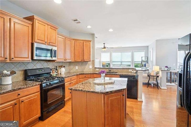 233 Hampton Station Blvd, Canton, GA 30115 - kitchen with black appliances, a center island, light stone counters, a peninsula, and recessed lighting