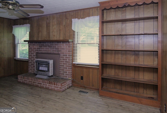 350 Laurel Ln, Lagrange, GA 30241 - unfurnished living room featuring heating unit, wood walls, wood finished floors, and a ceiling fan